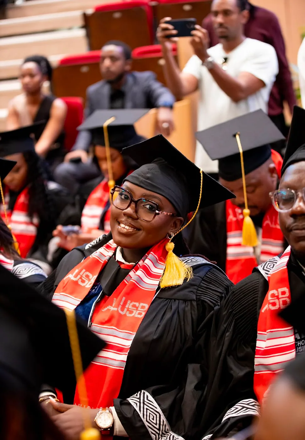 Nyampinga Laetitia seated in her graduation gown, cap and ALUSB stole